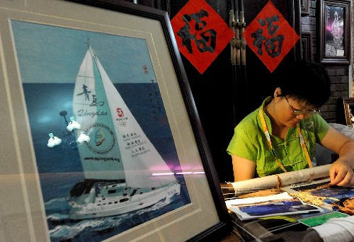 在青島奧運(yùn)村中國民俗展的展區(qū)內(nèi),一位刺繡藝人在現(xiàn)場制作繡品(7月27日攝)。 新華社記者 王頌 攝