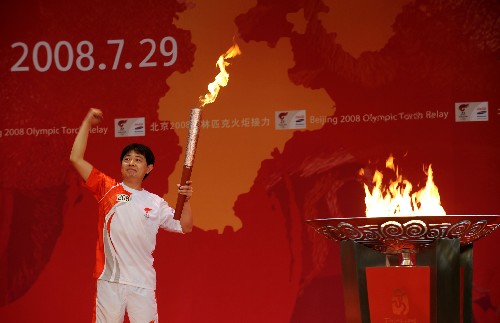 7月29日,最后一棒火炬手蔡亞林點(diǎn)燃圣火盆后向觀眾示意。當(dāng)日,北京奧運(yùn)圣火在河北省石家莊市傳遞。 新華社記者 鞏志宏 攝