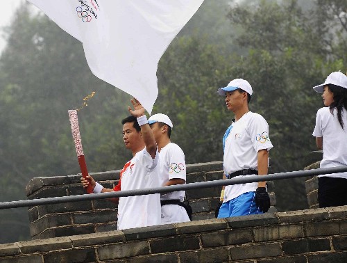 8月7日,火炬手李龍江手持火炬?zhèn)鬟f。當(dāng)日,北京奧運圣火在北京市傳遞。 新華社記者 戚恒 攝