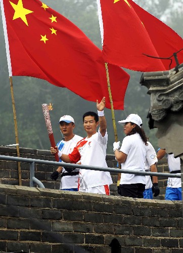 8月7日,火炬手李龍江手持火炬?zhèn)鬟f。當(dāng)日,北京奧運圣火在北京市傳遞。 新華社記者 戚恒 攝