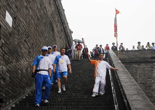 8月29日,最后一棒火炬手李輝民(前右)進(jìn)行傳遞。當(dāng)日,北京殘奧會圣火在西安進(jìn)行傳遞。 新華社記者 金良快 攝
