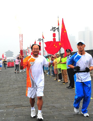 8月29日,火炬手李世政進(jìn)行火炬?zhèn)鬟f。當(dāng)日,北京殘奧會圣火在西安進(jìn)行傳遞。 新華社記者 張善臣 攝