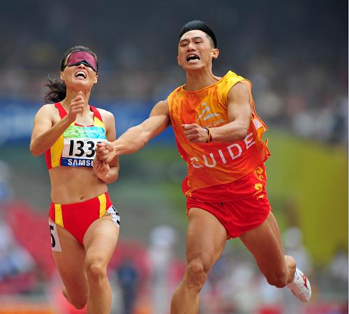 9月9日,中國選手吳春苗(左)與領(lǐng)跑員在比賽中。當日,在國家體育場進行的北京2008年殘奧會女子100米T11級決賽中,吳春苗以12秒31的成績奪得冠軍。 新華社記者 杜華舉 攝