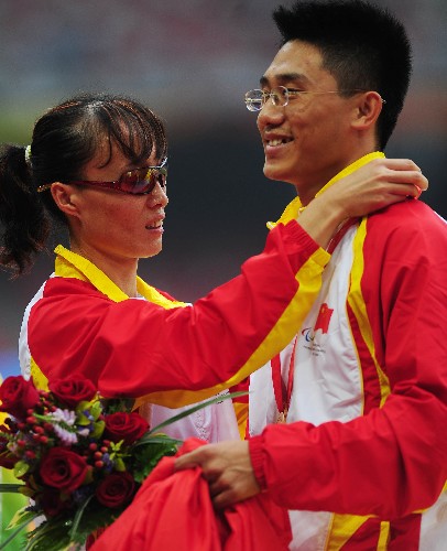 9月9日,中國選手吳春苗(左)在頒獎儀式上為領(lǐng)跑員佩戴自己的金牌。 新華社記者 李尕 攝