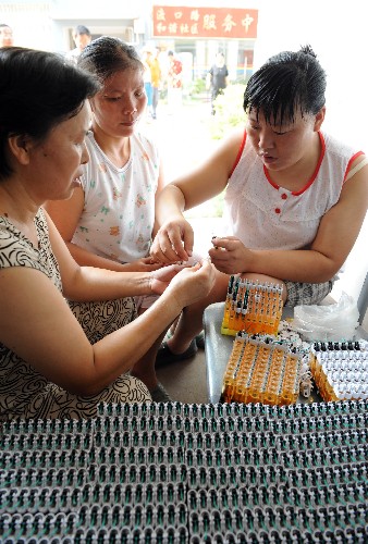 9月19日,渡口路社區(qū)的陳清華(右一)等在樓道口組裝打火機。 江西贛州市章貢區(qū)渡口路社區(qū)是贛州市集中安置老弱特困殘人員的首個廉租房社區(qū)。2007年以來,社區(qū)以“解決就業(yè)與再就業(yè)、扶貧幫困”為宗旨,創(chuàng)辦了社區(qū)“和諧創(chuàng)業(yè)社”,從生產(chǎn)廠家以訂單形式接回串燈泡、打火機組裝、信封加工以及鞝鞋底等十幾個手工制作業(yè)務(wù),讓社區(qū)居民足不出戶實現(xiàn)就業(yè)。 新華社記者 宋振平 攝