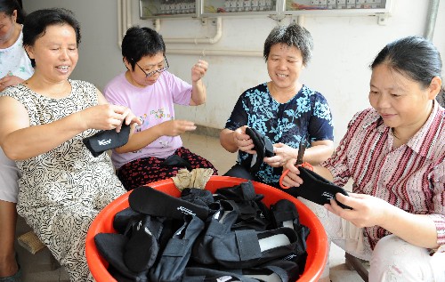 9月19日,渡口路社區(qū)困難戶龔冬英(右一)等在樓道口鞝鞋底。 新華社記者 宋振平 攝
