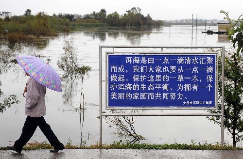 10月29日,在云南省大理白族自治州大理市上關(guān)鎮(zhèn),一名男子從一面洱海保護(hù)的宣傳牌旁走過。大理州近年來(lái)加大了對(duì)洱海保護(hù)的宣傳力度,在洱海周邊設(shè)立了數(shù)百塊宣傳牌,提高沿湖群眾的環(huán)保意識(shí)。 位于云南省大理白族自治州的洱海是云南第二大淡水湖泊,湖面面積253平方公里,也是大理風(fēng)景名勝區(qū)和蒼洱自然保護(hù)區(qū)的核心,被大理人民譽(yù)為“母親湖”。1996年和2003年,洱海兩次發(fā)生大面積藍(lán)藻暴發(fā),水質(zhì)一度降到IV類。為有效保護(hù)洱海生態(tài)環(huán)境,大理州從2003年開始“像保護(hù)眼睛一樣保護(hù)洱海”,先后投入資金近20億元,全面實(shí)施了洱海生態(tài)修復(fù)、環(huán)湖治污和截污、流域內(nèi)農(nóng)業(yè)農(nóng)村湖源污染治理等措施。目前洱海綜合治理已經(jīng)取得明顯成效,2008年前9個(gè)月的洱海水質(zhì)監(jiān)測(cè)結(jié)果表明:洱海水質(zhì)總體保持在II類,生態(tài)環(huán)境得到了明顯的改善,“高原明珠”重放光彩。 新華社記者藺以光攝