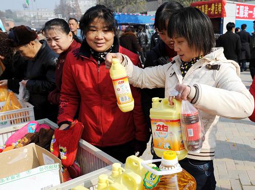 12月17日,南昌市組織的20輛貨車在南昌縣向塘鎮(zhèn)促銷,顧客在現(xiàn)場選購日用品。新華社發(fā)(周科 攝)