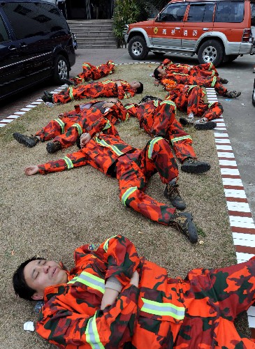 2月13日,經(jīng)過一夜的撲火戰(zhàn)斗的森林消防官兵在路邊休息。 新華社記者 張國俊 攝