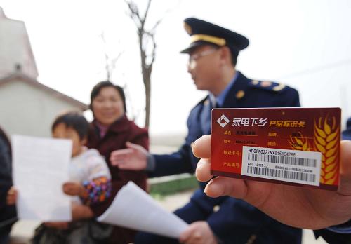 3月8日,重慶市工商局潼南分局的一名工商執(zhí)法人員在展示“家電下鄉(xiāng)”商品必須有的“產(chǎn)品標(biāo)識(shí)卡”。 新華社記者 劉潺 攝