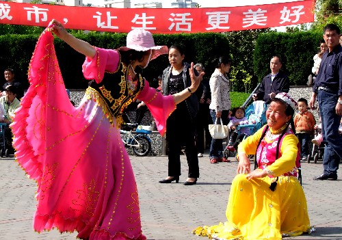 市民身穿盛裝在街頭起舞,迎接上海世博會(huì)開幕倒計(jì)時(shí)一周年(4月26日攝)。 新華社記者 張明 攝