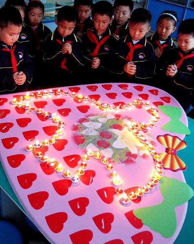 5月11日,濟(jì)南市大明湖小學(xué)的同學(xué)為地震災(zāi)區(qū)的人民祈福平安。當(dāng)日,該校舉行了“防災(zāi)減災(zāi)手牽手,互救互助心連心”為主題的汶川地震一周年紀(jì)念活動(dòng)。同學(xué)們?cè)跔T光中緬懷逝者,為災(zāi)區(qū)人民祈愿。 新華社發(fā)