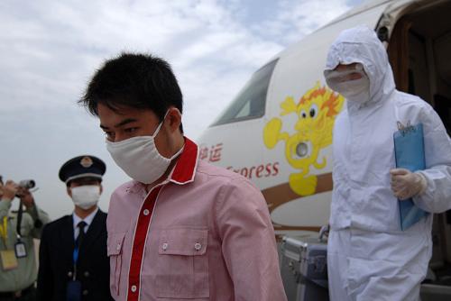 5月12日,在西安咸陽國際機(jī)場舉行的演練中,“患者”在“醫(yī)生”的護(hù)送下走出機(jī)艙。當(dāng)日,陜西省衛(wèi)生廳與西安咸陽國際機(jī)場聯(lián)合組織甲型H1N1流感事件應(yīng)急處置模擬演練,以期鍛煉、提高應(yīng)對甲型H1N1流感的指揮協(xié)調(diào)、處置保障能力。模擬演練情節(jié)為,在一架由上海浦東機(jī)場飛往西安咸陽國際機(jī)場的航班上,一位旅客出現(xiàn)甲型H1N1流感疑似癥狀,西安咸陽國際機(jī)場現(xiàn)場運(yùn)行中心,在飛機(jī)降落后迅速啟動實(shí)施“西安咸陽國際機(jī)場突發(fā)公共衛(wèi)生事件應(yīng)急處理預(yù)案”。新華社記者 丁海濤 攝