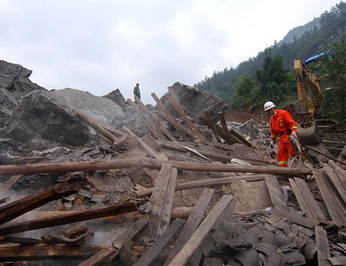 6月7日,一名消防戰(zhàn)士正在山體垮塌現場的廢墟上勘察水帶鋪設線路。 新華社記者 劉潺 攝
