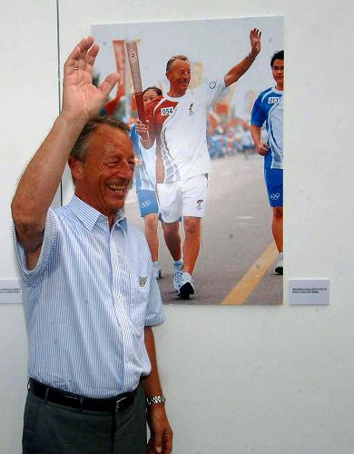 8月8日,國際奧委會執(zhí)委會委員吉哈德·海博格在展出的他傳遞火炬的照片前拍照留念。新華社記者公磊攝