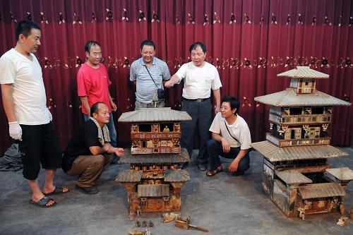 8月13日,文物工作者觀賞新出土的彩繪陶倉(cāng)樓。新華社發(fā)(楊帆 攝)