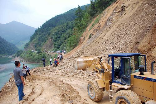 8月14日,貴州省榕江公路管理段路政人員用裝載機在321國道上清理塌方土石。新華社發(fā)(陳沛亮 攝)