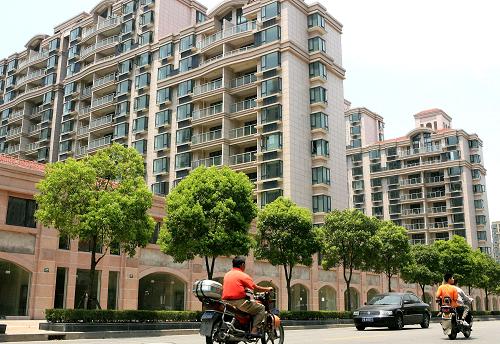 車輛從上海市共和新路旁一新建樓盤前經(jīng)過(7月20日攝)。新華社記者陳飛攝