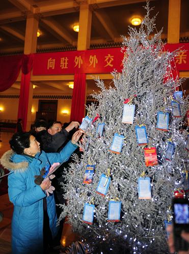 12月26日,聯(lián)歡會開始前,部分外交人員家屬將填好的親情卡掛在親情樹上,親情卡將隨聯(lián)歡會光盤被送至駐外使領(lǐng)館親人處。新華社記者 張鐸 攝