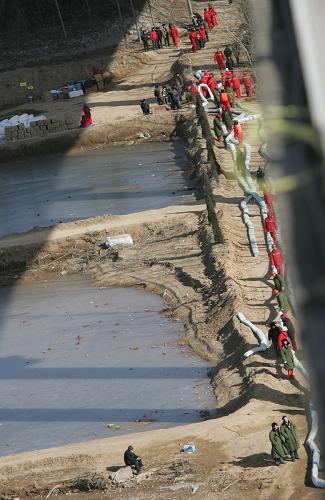 1月4日,三門峽黃河公路大橋下的“截油”大軍緊張工作。新華社發(fā) (張曉理 攝)
