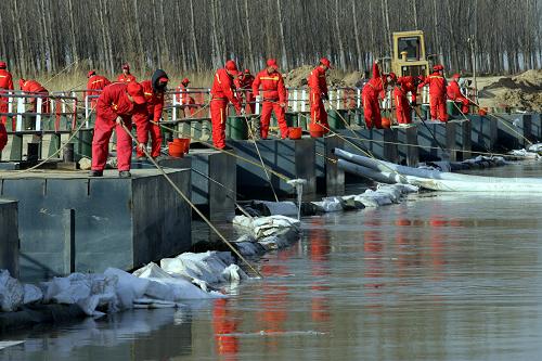 1月4日,搶險(xiǎn)人員使用凝油劑在渭河入黃處打撈泄漏的柴油。新華社發(fā)(袁景智 攝)