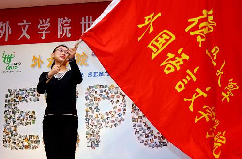 3月12日,復(fù)旦大學(xué)外文學(xué)院的世博志愿者代表在誓師大會(huì)上揮舞院旗。新華社記者 劉穎 攝