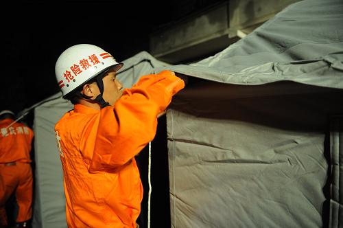 5月6日晚,消防官兵正在墊江縣沙坪鎮(zhèn)李白村搭建救災(zāi)帳篷。新華社記者周衡義攝
