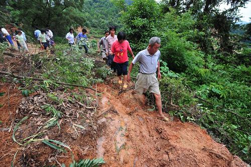 廣西蒼梧縣沙頭鎮(zhèn)道路被泥石掩埋,村民艱難轉(zhuǎn)移(6月16日)。新華社記者 黃孝邦攝