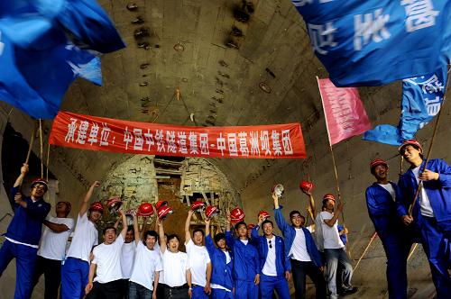 6月22日,工程建設(shè)者在南水北調(diào)中線穿黃工程貫通的隧洞口慶賀。當(dāng)日,南水北調(diào)中線穿黃工程上游線隧洞全線貫通。穿黃工程是通過明渠和并排的兩條隧洞把中線調(diào)水從黃河南岸輸送到北岸,隧洞工程從水下40米處橫穿黃河,單洞長達(dá)4250米,是南水北調(diào)中線工程中的控制性工程。新華社記者朱祥攝