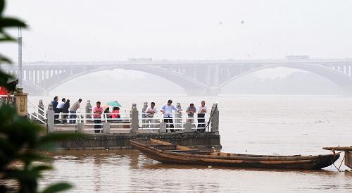 6月25日,長(zhǎng)沙市民在湘江邊觀(guān)察過(guò)境洪峰。新華社記者 龍弘濤 攝