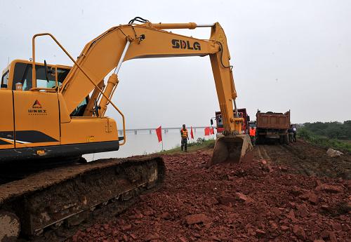 6月25日,挖掘機(jī)在唱?jiǎng)P堤平整施工道路。新華社記者章武攝