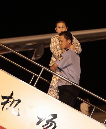 8月25日,一名警察將一名小傷員送上飛機(jī)。新華社記者邢廣利攝
