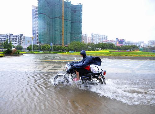 9月20日,一名市民騎著摩托車經(jīng)過福建漳州市區(qū)積水的道路。 當(dāng)日,今年第11號臺(tái)風(fēng)“凡亞比”在福建漳浦縣古雷鎮(zhèn)登陸。“凡亞比”給福建部分地區(qū)帶來強(qiáng)降雨,福建省氣象臺(tái)12時(shí)53分發(fā)布暴雨黃色預(yù)警信號,提醒須特別注意防范降水可能引發(fā)的城市積澇及泥石流、山體滑坡等次生災(zāi)害。 新華社記者魏培全攝