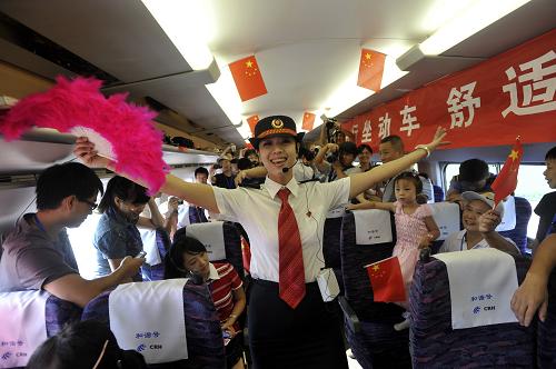 9月20日,在南昌開往九江的“和諧號(hào)”高速動(dòng)車內(nèi),一名乘務(wù)員表演節(jié)目慶祝昌九城際高鐵開通。新華社發(fā)(熊家福 攝)
