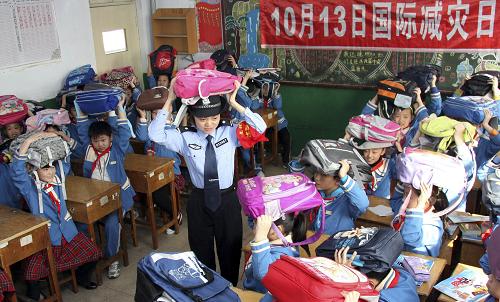10月13日,山東棗莊市市中區(qū)文化路小學(xué)法制副校長李媛媛為學(xué)生們講解地震自救、逃生知識。新華社發(fā)(孫中喆 攝)