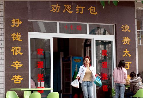 ??谑旋埨ツ下飞弦患覄傞_業(yè)的臨街餐廳,在店門口貼上醒目的對聯(lián),提醒食客將吃剩的飯菜打包回家,減少浪費(2007年1月6日攝)。新華社發(fā)(彭桐攝)