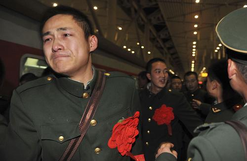 11月24日,武警陜西總隊(duì)延安市支隊(duì)的退伍老兵和送行的戰(zhàn)友們?cè)谘影不疖囌倦y分難舍。新華社發(fā)(祁小軍 攝)