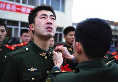 11月25日,在山東煙臺(tái)邊防舉行的士兵退役儀式上,一名即將退役的戰(zhàn)士在摘下帽徽、肩章時(shí)淚流滿面。 新華社發(fā)(初陽 攝)