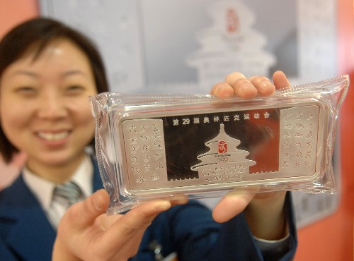 11月10日,在北京菜市口百貨商場(chǎng),一名工作人員在展示“鳥巢”銀條。 新華社發(fā)