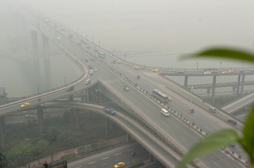 這是11月14日14時許拍攝的霧中的重慶嘉陵江黃花園大橋。 新華社記者 周衡義 攝
