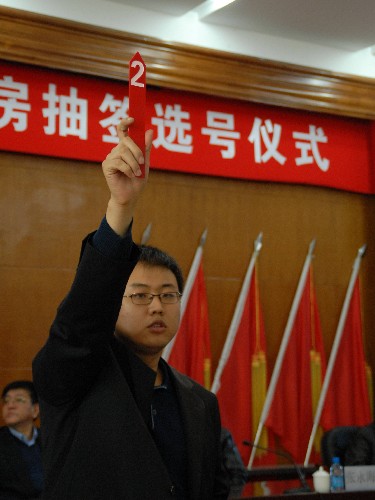 11月14日,哈爾濱市2007年度廉租住房抽簽選號儀式舉行,公證人員公示享受廉租住房待遇的市民選出的號碼。 新華社發(fā)(張清云 攝)