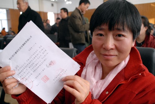 11月14日,哈爾濱市2007年度廉租住房抽簽選號儀式舉行,一名市民展示拿到的廉租住房實物配租確認(rèn)單。 新華社發(fā)(張清云 攝)