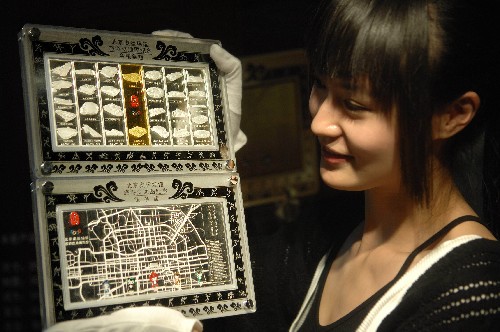 12月5日,工作人員展示“北京奧運(yùn)場館旅游交通圖紀(jì)念金銀條版”。 新華社發(fā)
