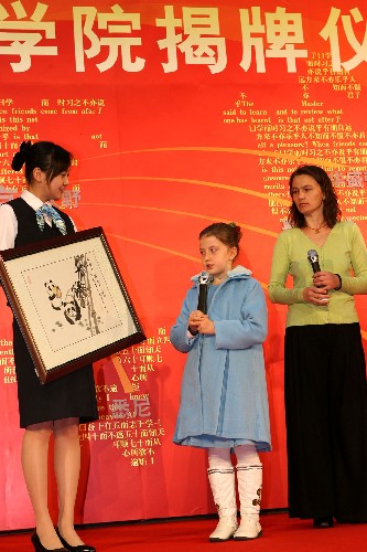 12月6日,9歲的塞爾維亞女孩蘇俐娜(中)向廣播孔子學(xué)院贈(zèng)送自己的畫作。 新華社記者 李明放 攝