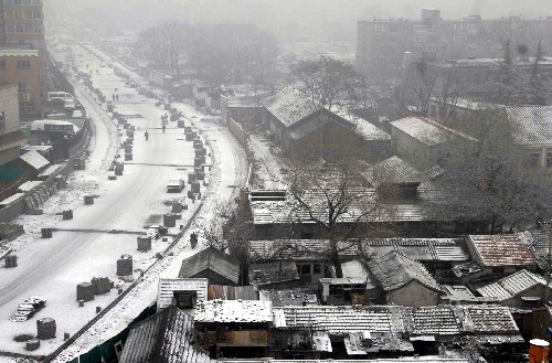 12月10日,北京市宣武區(qū)一居民小區(qū)的道路和民房屋頂上覆蓋著一層薄雪。 新華社記者 羅曉光 攝