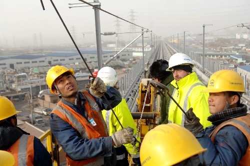 12月28日,在京津城際鐵路北京南站至亦莊區(qū)間施工現(xiàn)場(chǎng),中國(guó)中鐵電氣化局一公司員工架設(shè)北京區(qū)段的第一條接觸網(wǎng)導(dǎo)線。 新華社發(fā)