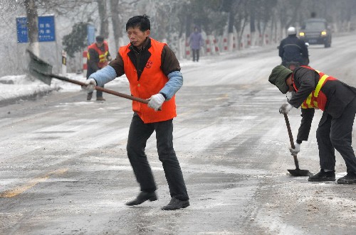 1月25日,工作人員在湖南寧鄉(xiāng)縣境內(nèi)的319國道上撒鹽除冰。 新華社記者 龍弘濤 攝