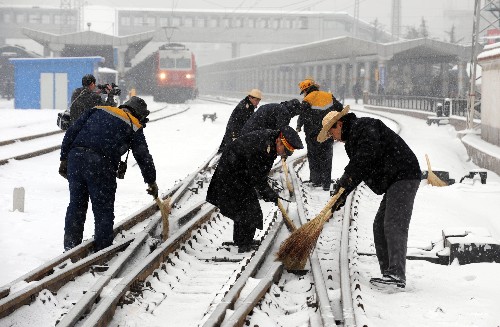 1月27日,蘭州火車站工作人員緊急清掃鐵軌道岔上的積雪。 新華社記者 韓傳號(hào) 攝
