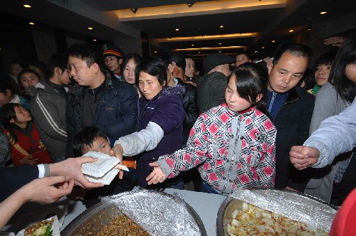 1月29日,疏散到湖南省湘潭市的京珠高速滯留人員在安置賓館排隊(duì)領(lǐng)飯。 新華社記者 龍弘濤 攝