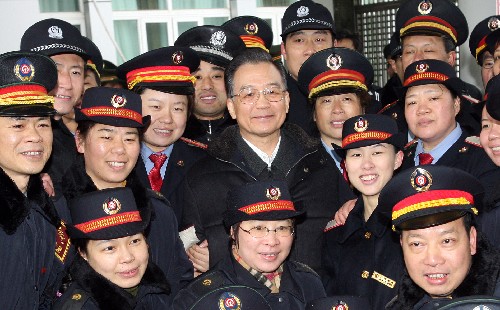 1月30日,中共中央政治局常委、國務院總理溫家寶在廣州火車站親切接見了日夜奮戰(zhàn)在春運一線的武警官兵、公安干警和鐵路職工。這是溫家寶和鐵路職工合影。 新華社記者 姚大偉 攝